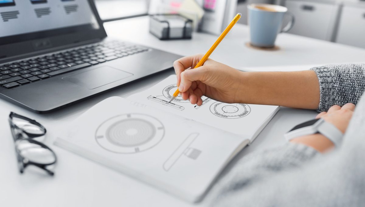 app design, technology and business concept - web designer or developer working on user interface and drawing sketches at office